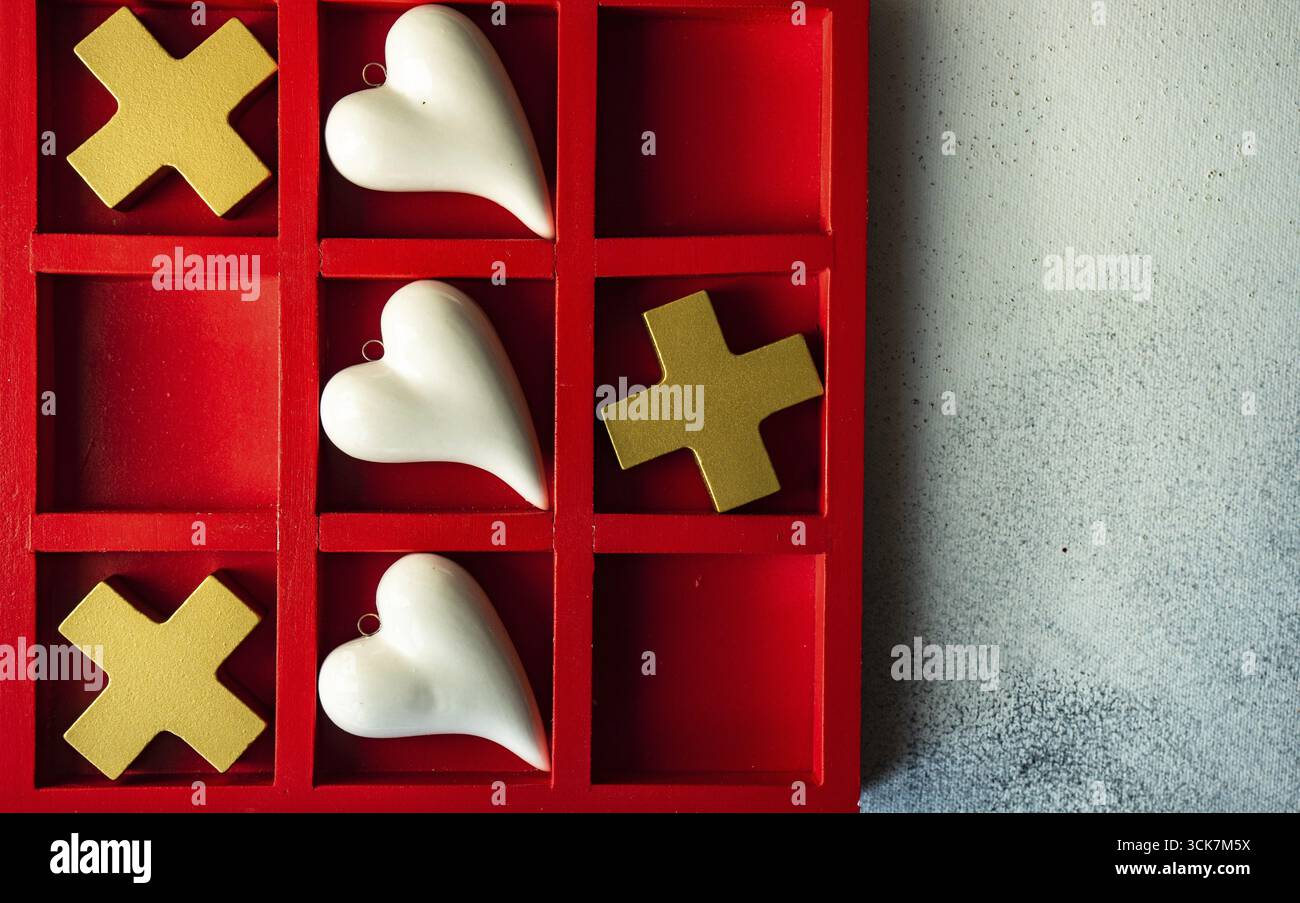Kartenkonzept St. Valentine mit Tic-tac-Toe Brettspiel und Herzen auf steinweißem Hintergrund mit Kopierraum Stockfoto