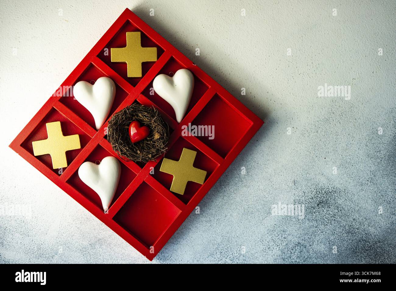 Kartenkonzept St. Valentine mit Tic-tac-Toe Brettspiel und Herzen auf steinweißem Hintergrund mit Kopierraum Stockfoto