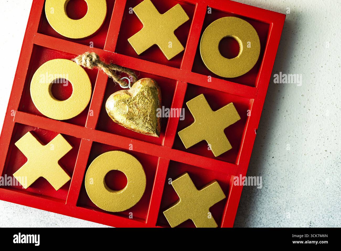 Kartenkonzept St. Valentine mit Tic-tac-Toe Brettspiel und Herzen auf steinweißem Hintergrund mit Kopierraum Stockfoto