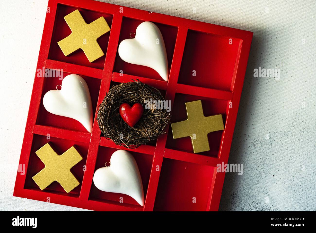Kartenkonzept St. Valentine mit Tic-tac-Toe Brettspiel und Herzen auf steinweißem Hintergrund mit Kopierraum Stockfoto
