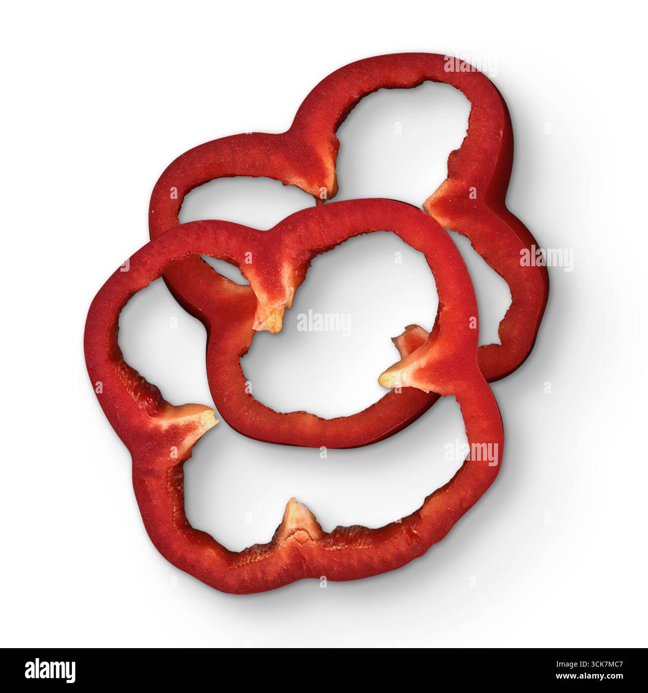 Rote Paprikascheiben werden kreativ angeordnet und zeigen ihre lebendige Farbe und Textur. Stockfoto
