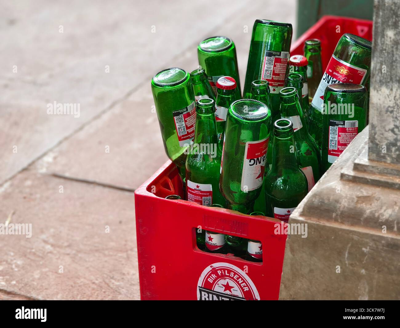 Sanur, Bali, Indonesien – 6. September 2025: Leere grüne Bierflaschen der Marke Bintang werden in einer roten Kunststoffkiste zum Recycling gesammelt Stockfoto