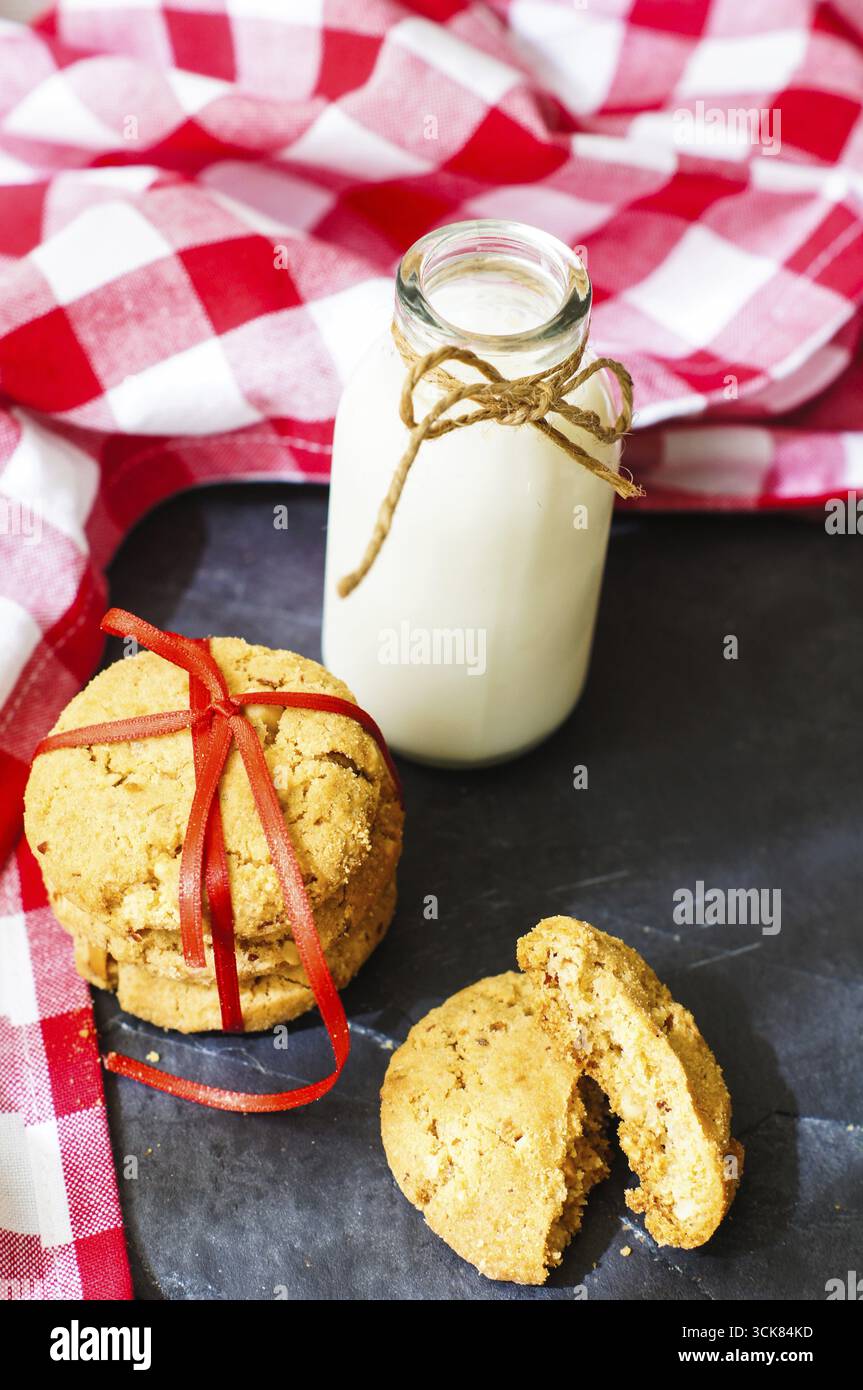 Milch und Kekse auf der helle Serviette auf dem Tablett aus Holz Stockfoto
