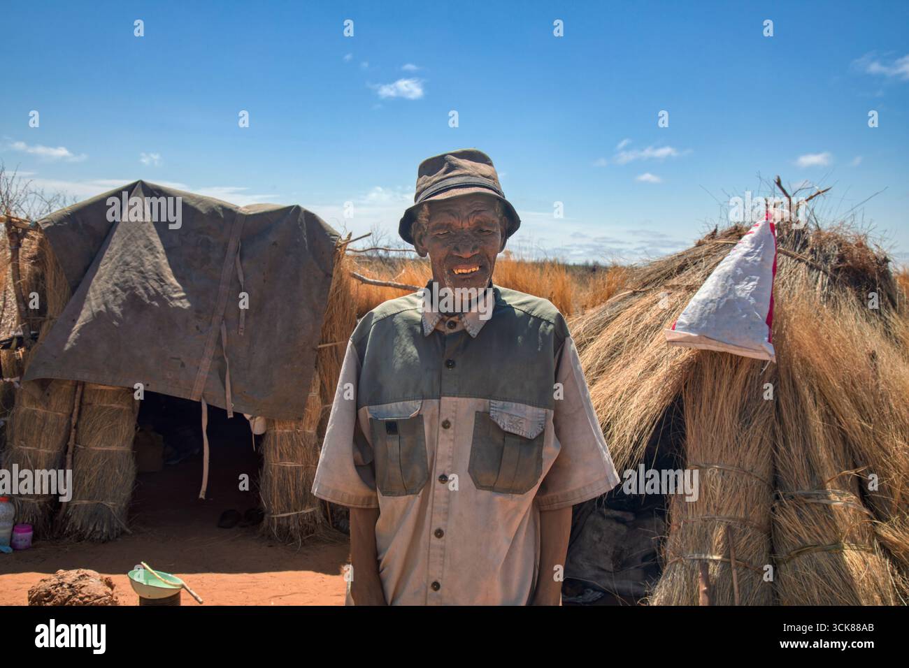 Afrikanischer alter Mann mit Hut vor seinem Strohhaus in Botswana, Flüchtlingslager Stockfoto