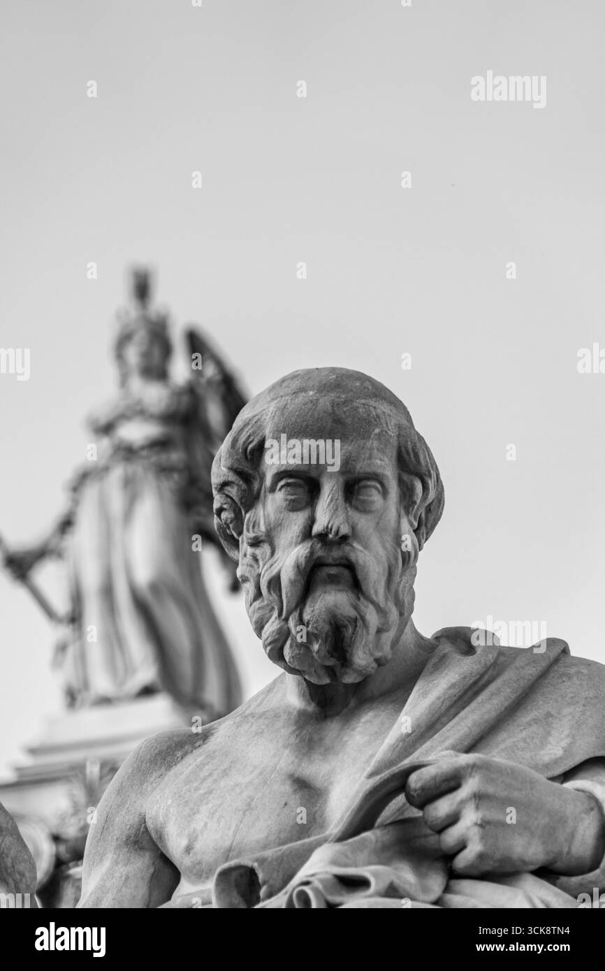 Marmor-Statue von Platon von Leonidas Drosis. Athena-Kolumne im Hintergrund vor der Akademie von Athen, Griechenland – Mai 2025 Stockfoto