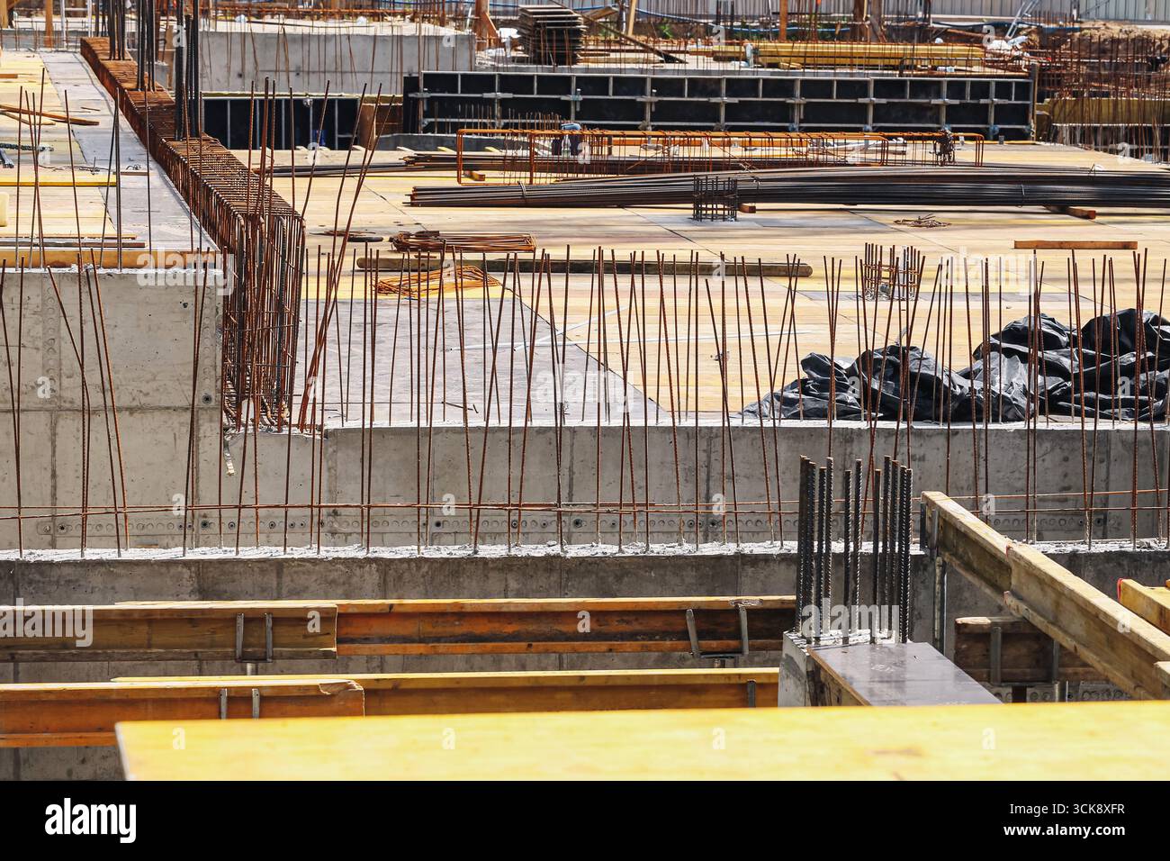 Baustelle mit Stahlverstärkung. Gebäudefundament mit Eisenstangen. Industriearchitektur im Gange. Struktur der Arbeit. Stockfoto