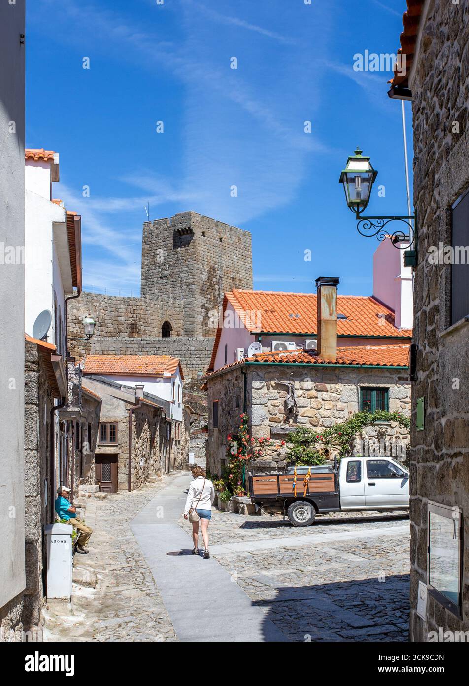 Frau, die durch das mittelalterliche portugiesische Dorf Linhares de Beira Portugal geht Stockfoto