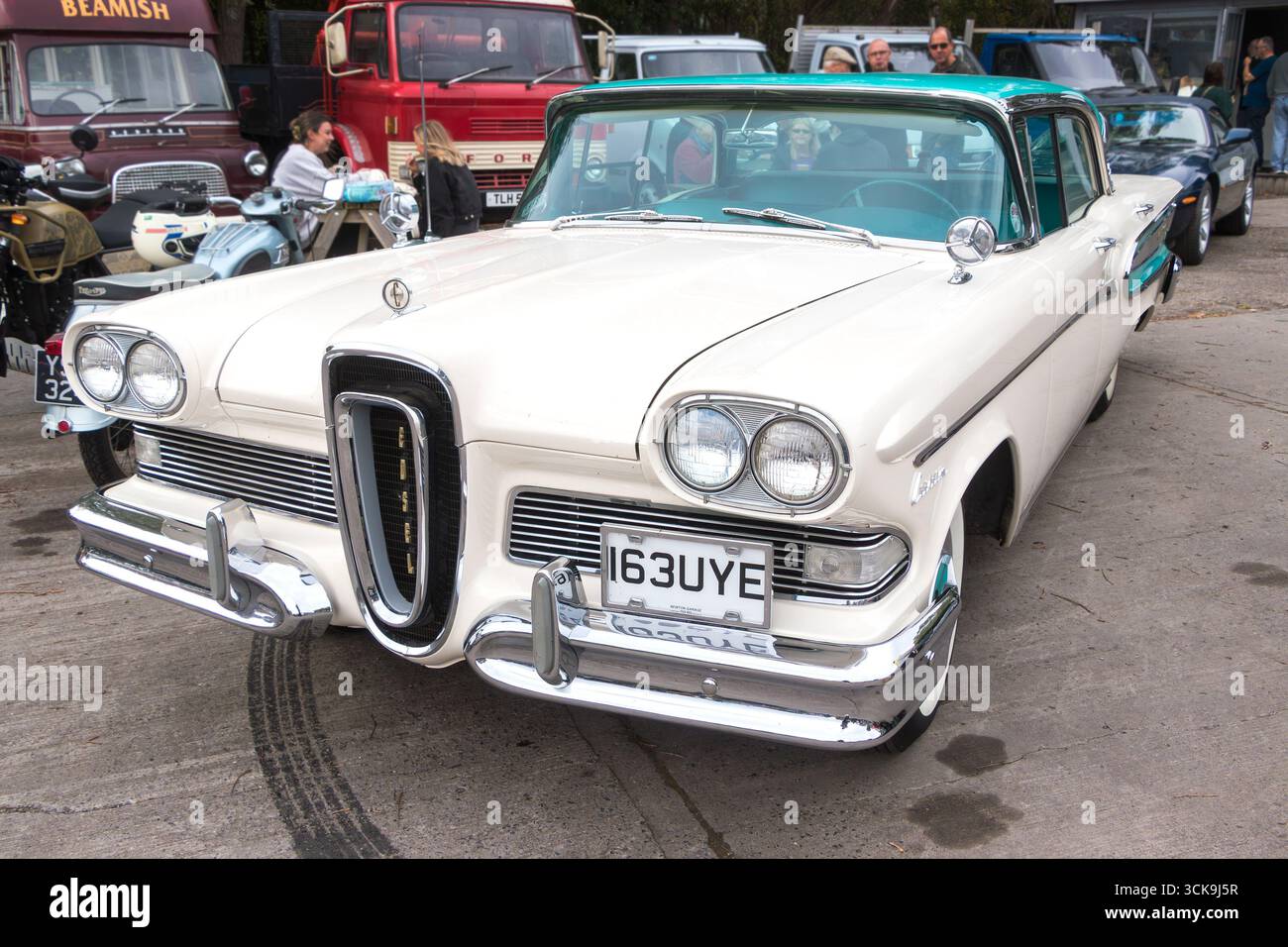 Ein Cabriolet von Edsel wird auf einer Autoversteigerung präsentiert, umgeben von Menschen und anderen Oldtimern Stockfoto
