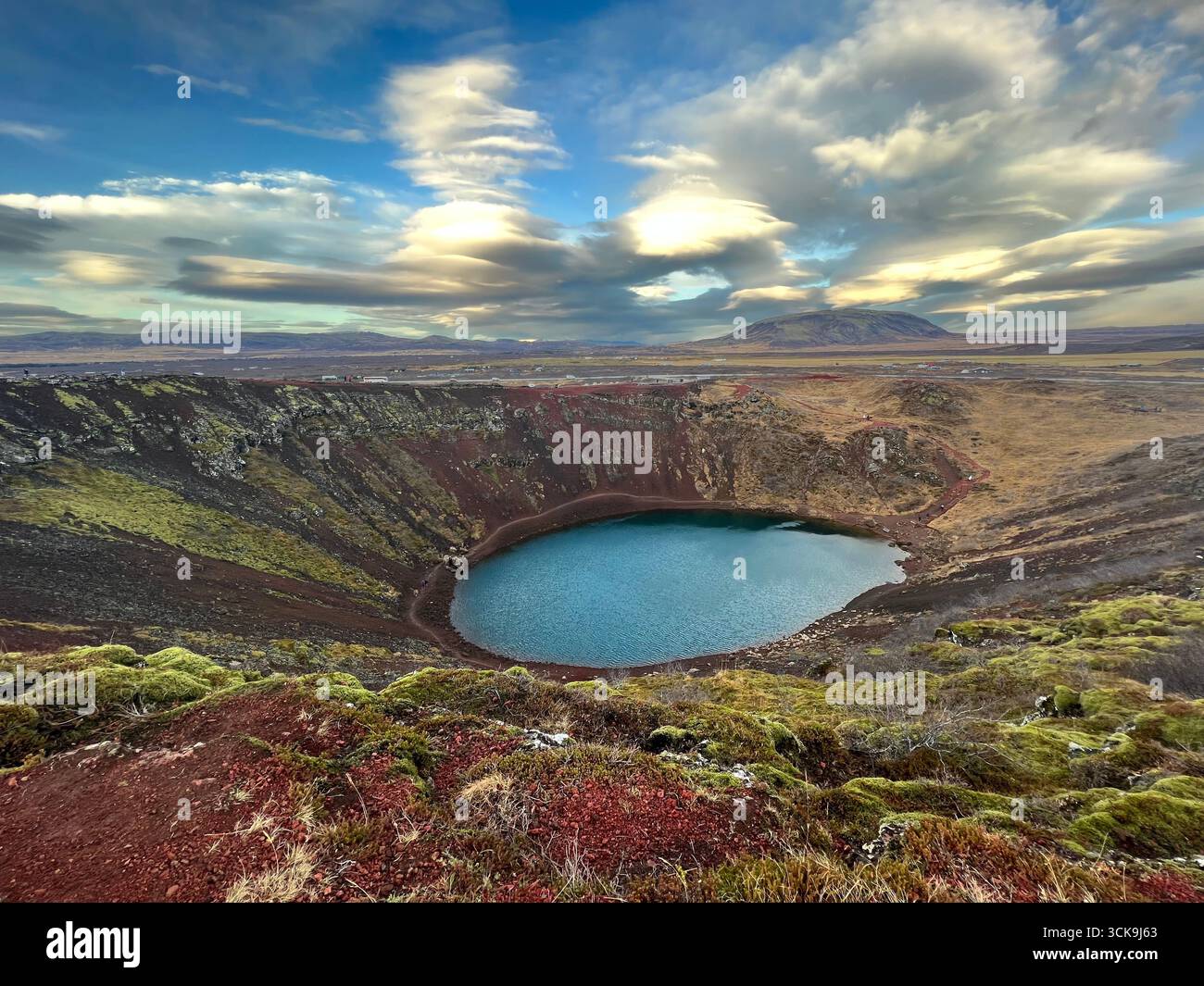 Der vulkanische Kratersee am Goldenen Kreis in Südisland, der aus einem abgestürzten Vulkan mit rotem vulkanischem Gestein und blau-grünem Wasser gebildet wurde Kerið. Stockfoto