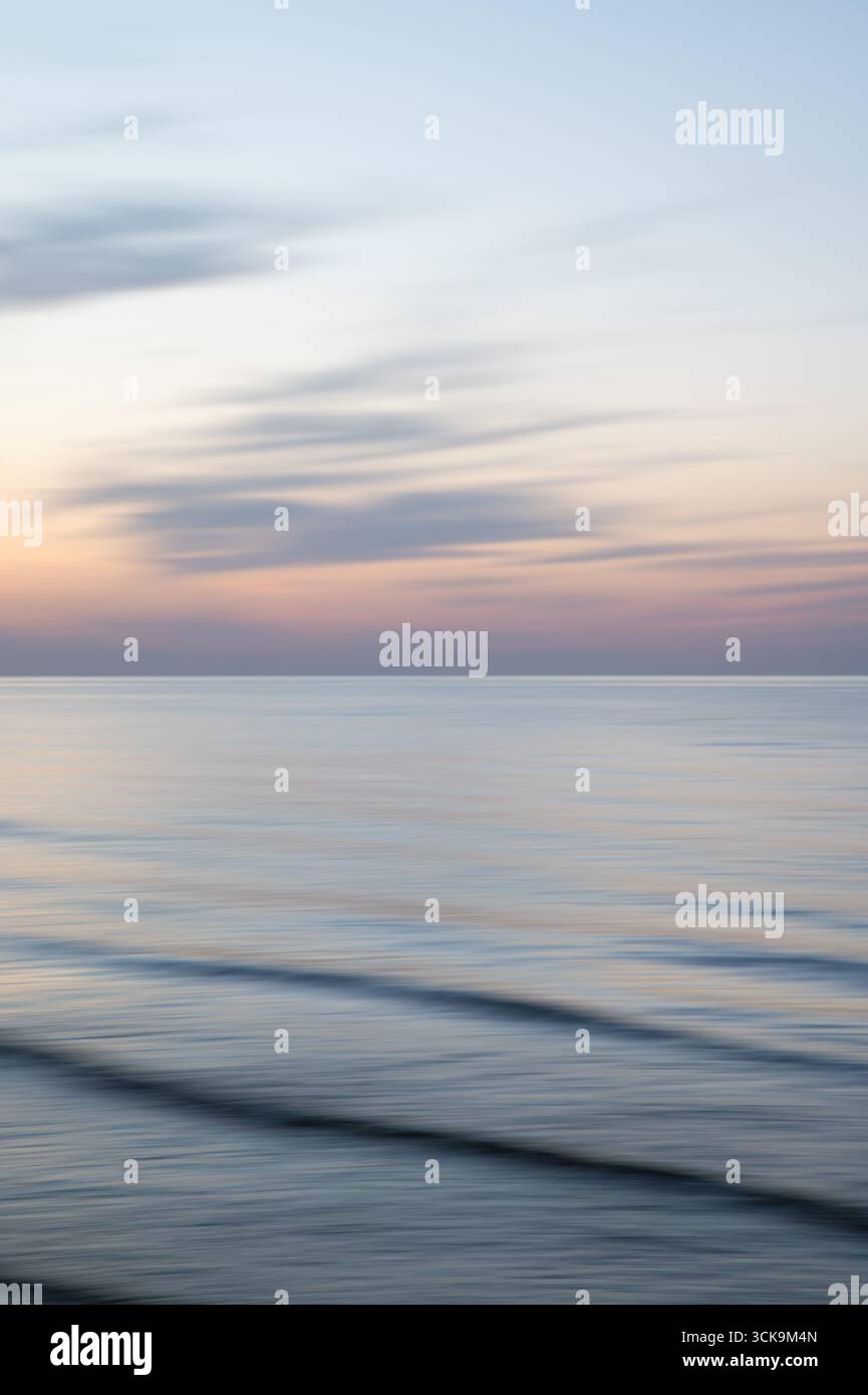 Eine traumhafte, impressionistische Farbe wie ein verschwommener Hintergrund bei Sonnenuntergang mit sanften Pastellfarben. Vertikales Foto. Stockfoto