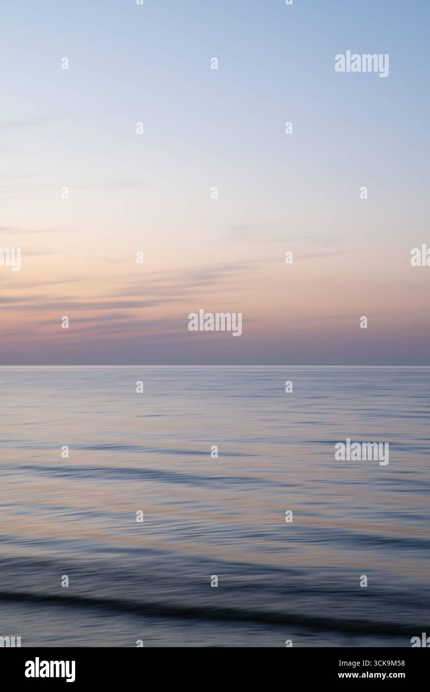 Eine traumhafte, impressionistische Farbe wie ein verschwommener Hintergrund bei Sonnenuntergang mit sanften Pastellfarben. Vertikales Foto. Stockfoto