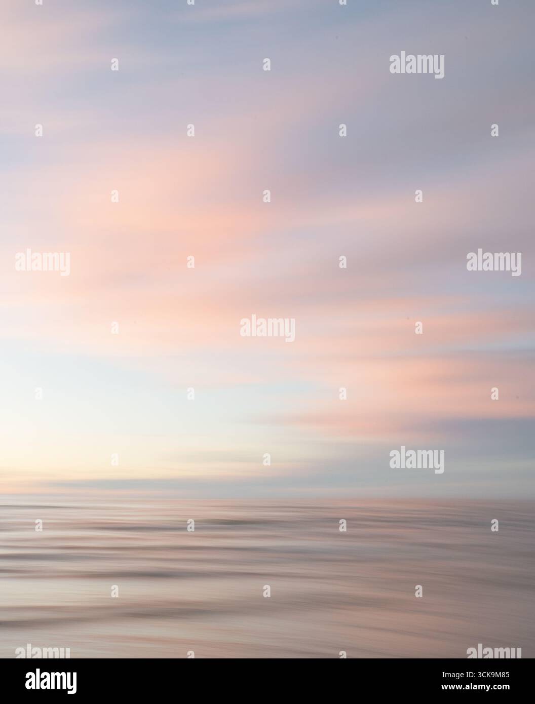 Eine traumhafte, impressionistische Farbe wie ein verschwommener Hintergrund bei Sonnenuntergang mit sanften Pastellfarben. Vertikales Foto. Stockfoto