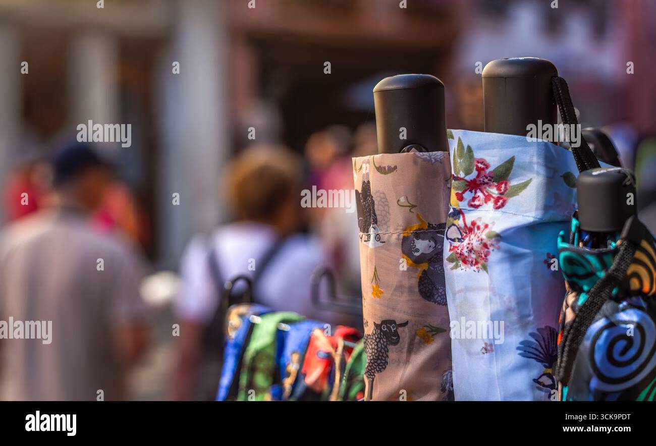 Bunte Regenschirme mit Blumen- und abstrakten Motiven auf einem Straßenmarkt in Ribeauville, Elsass. Stockfoto