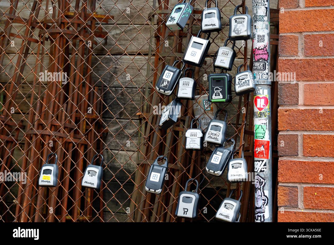 Schließfächer und Schlüsselsafes für Haustiersitter, Self-Service-Check-in für Gäste, verschlossen an einem rostigen Zaun in New York City. Stockfoto