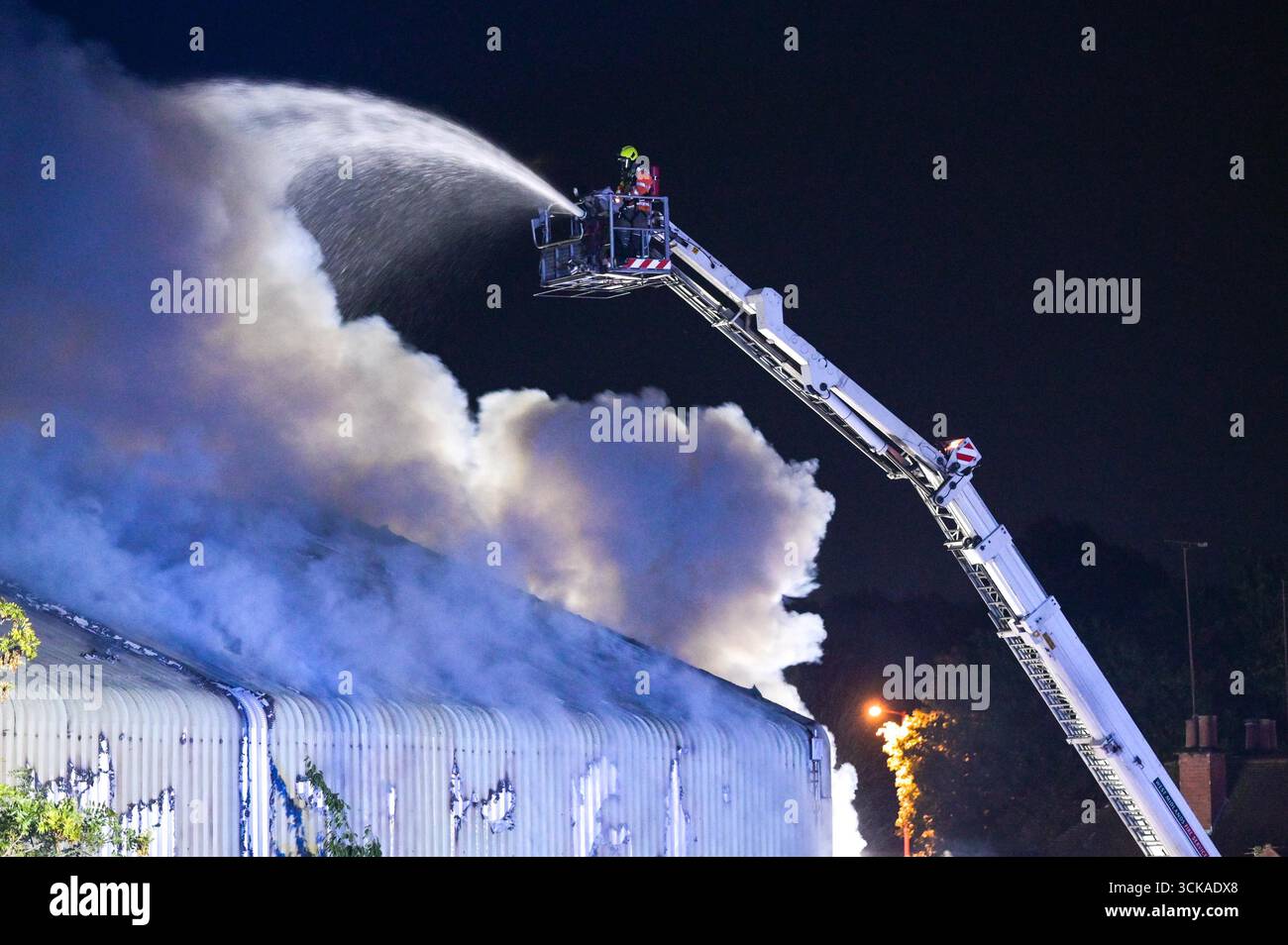Longbridge, Birmingham, 11. September 2025. Mehr als 60 Feuerwehrleute sind in den frühen Morgenstunden des Donnerstags bei einem großen Brand in Longbridge, Birmingham, anwesend. Die Flamme hat Frankley Tyre Lagerhaus auf dem alten Gelände des MG Rover West Works erobert. Zwölf Feuerwehrfahrzeuge, zwei hydraulische Plattformen, die Vorfallskommando und verschiedene andere Ressourcen der Polizei, Cadent und des National Grid waren anwesend. Flammen leckten das Gebäude ab, als Wände einstürzten und die Feuerwehr Wasser mit Schläuchen besprühte. Die West Midlands Fire Service sagte in einem Beitrag auf Facebook: „Wir haben 12 Mannschaften, die bei einem Brand auf W anwesend sind Stockfoto