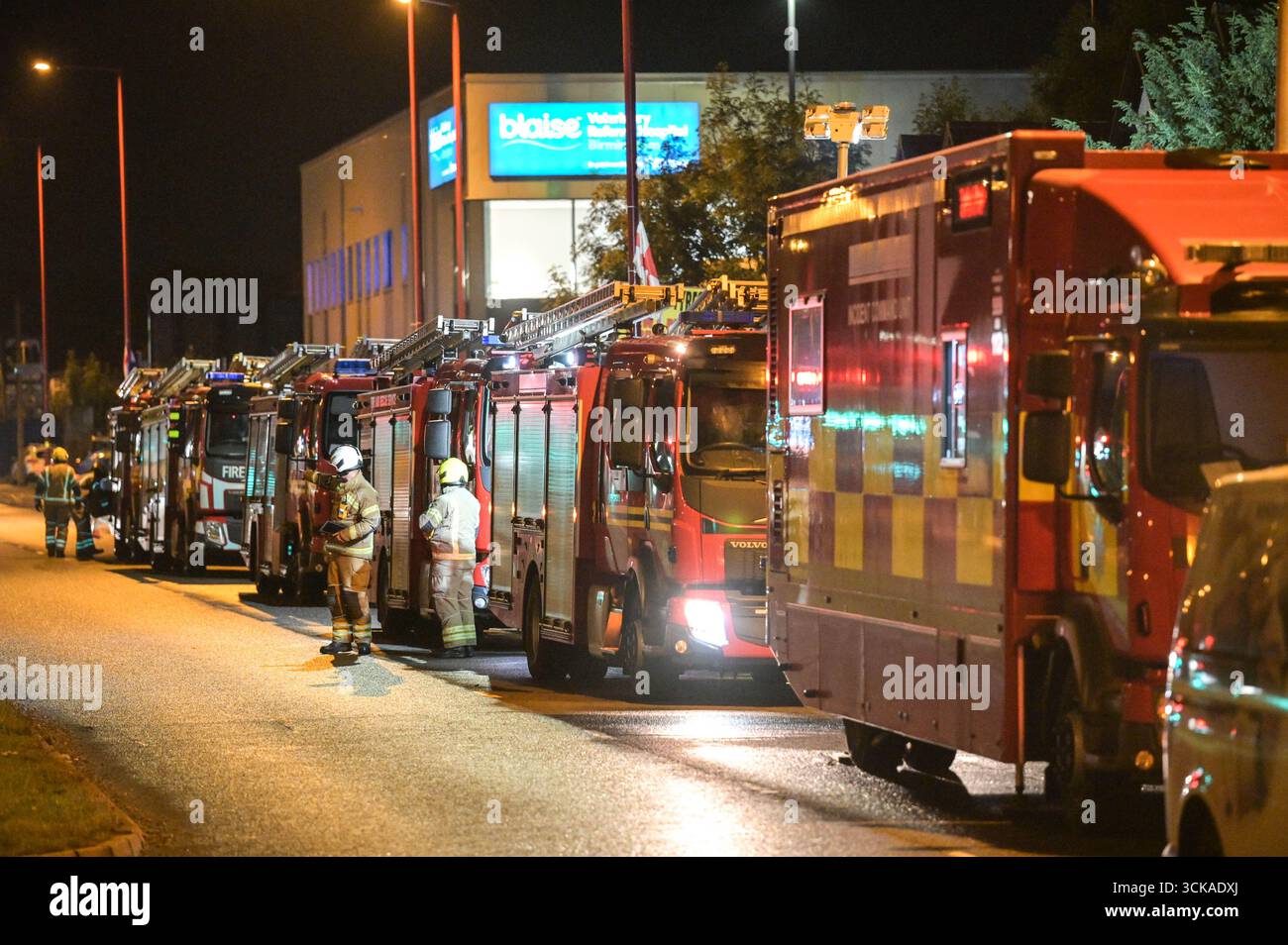 Longbridge, Birmingham, 11. September 2025. Mehr als 60 Feuerwehrleute sind in den frühen Morgenstunden des Donnerstags bei einem großen Brand in Longbridge, Birmingham, anwesend. Die Flamme hat Frankley Tyre Lagerhaus auf dem alten Gelände des MG Rover West Works erobert. Zwölf Feuerwehrfahrzeuge, zwei hydraulische Plattformen, die Vorfallskommando und verschiedene andere Ressourcen der Polizei, Cadent und des National Grid waren anwesend. Flammen leckten das Gebäude ab, als Wände einstürzten und die Feuerwehr Wasser mit Schläuchen besprühte. Die West Midlands Fire Service sagte in einem Beitrag auf Facebook: „Wir haben 12 Mannschaften, die bei einem Brand auf W anwesend sind Stockfoto