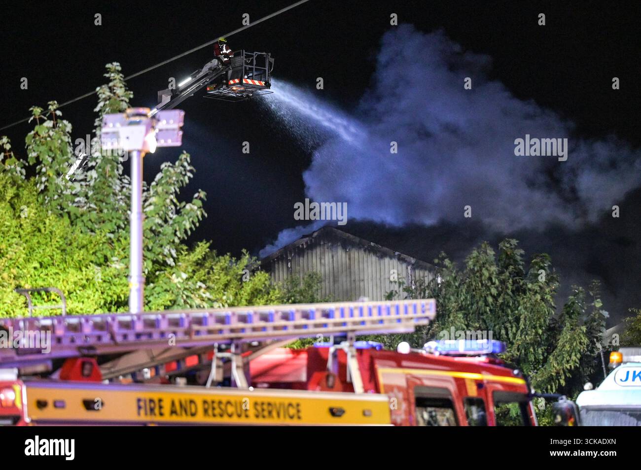 Longbridge, Birmingham, 11. September 2025. Mehr als 60 Feuerwehrleute sind in den frühen Morgenstunden des Donnerstags bei einem großen Brand in Longbridge, Birmingham, anwesend. Die Flamme hat Frankley Tyre Lagerhaus auf dem alten Gelände des MG Rover West Works erobert. Zwölf Feuerwehrfahrzeuge, zwei hydraulische Plattformen, die Vorfallskommando und verschiedene andere Ressourcen der Polizei, Cadent und des National Grid waren anwesend. Flammen leckten das Gebäude ab, als Wände einstürzten und die Feuerwehr Wasser mit Schläuchen besprühte. Die West Midlands Fire Service sagte in einem Beitrag auf Facebook: „Wir haben 12 Mannschaften, die bei einem Brand auf W anwesend sind Stockfoto