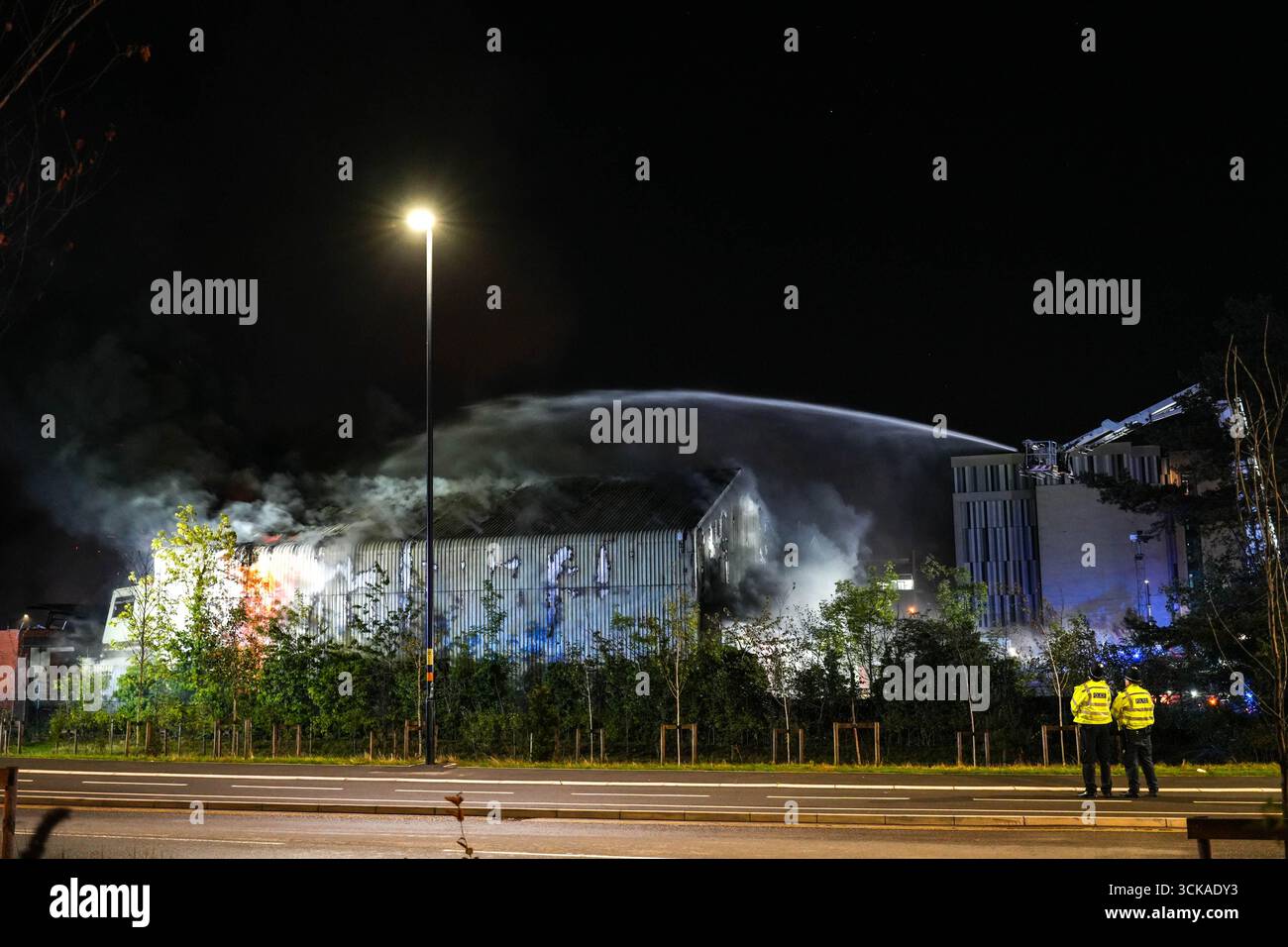 Longbridge, Birmingham, 11. September 2025. Mehr als 60 Feuerwehrleute sind in den frühen Morgenstunden des Donnerstags bei einem großen Brand in Longbridge, Birmingham, anwesend. Die Flamme hat Frankley Tyre Lagerhaus auf dem alten Gelände des MG Rover West Works erobert. Zwölf Feuerwehrfahrzeuge, zwei hydraulische Plattformen, die Vorfallskommando und verschiedene andere Ressourcen der Polizei, Cadent und des National Grid waren anwesend. Flammen leckten das Gebäude ab, als Wände einstürzten und die Feuerwehr Wasser mit Schläuchen besprühte. Die West Midlands Fire Service sagte in einem Beitrag auf Facebook: „Wir haben 12 Mannschaften, die bei einem Brand auf W anwesend sind Stockfoto