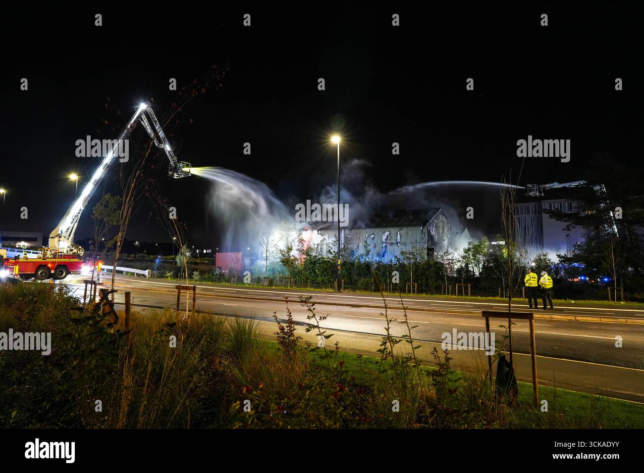 Longbridge, Birmingham, 11. September 2025. Mehr als 60 Feuerwehrleute sind in den frühen Morgenstunden des Donnerstags bei einem großen Brand in Longbridge, Birmingham, anwesend. Die Flamme hat Frankley Tyre Lagerhaus auf dem alten Gelände des MG Rover West Works erobert. Zwölf Feuerwehrfahrzeuge, zwei hydraulische Plattformen, die Vorfallskommando und verschiedene andere Ressourcen der Polizei, Cadent und des National Grid waren anwesend. Flammen leckten das Gebäude ab, als Wände einstürzten und die Feuerwehr Wasser mit Schläuchen besprühte. Die West Midlands Fire Service sagte in einem Beitrag auf Facebook: „Wir haben 12 Mannschaften, die bei einem Brand auf W anwesend sind Stockfoto