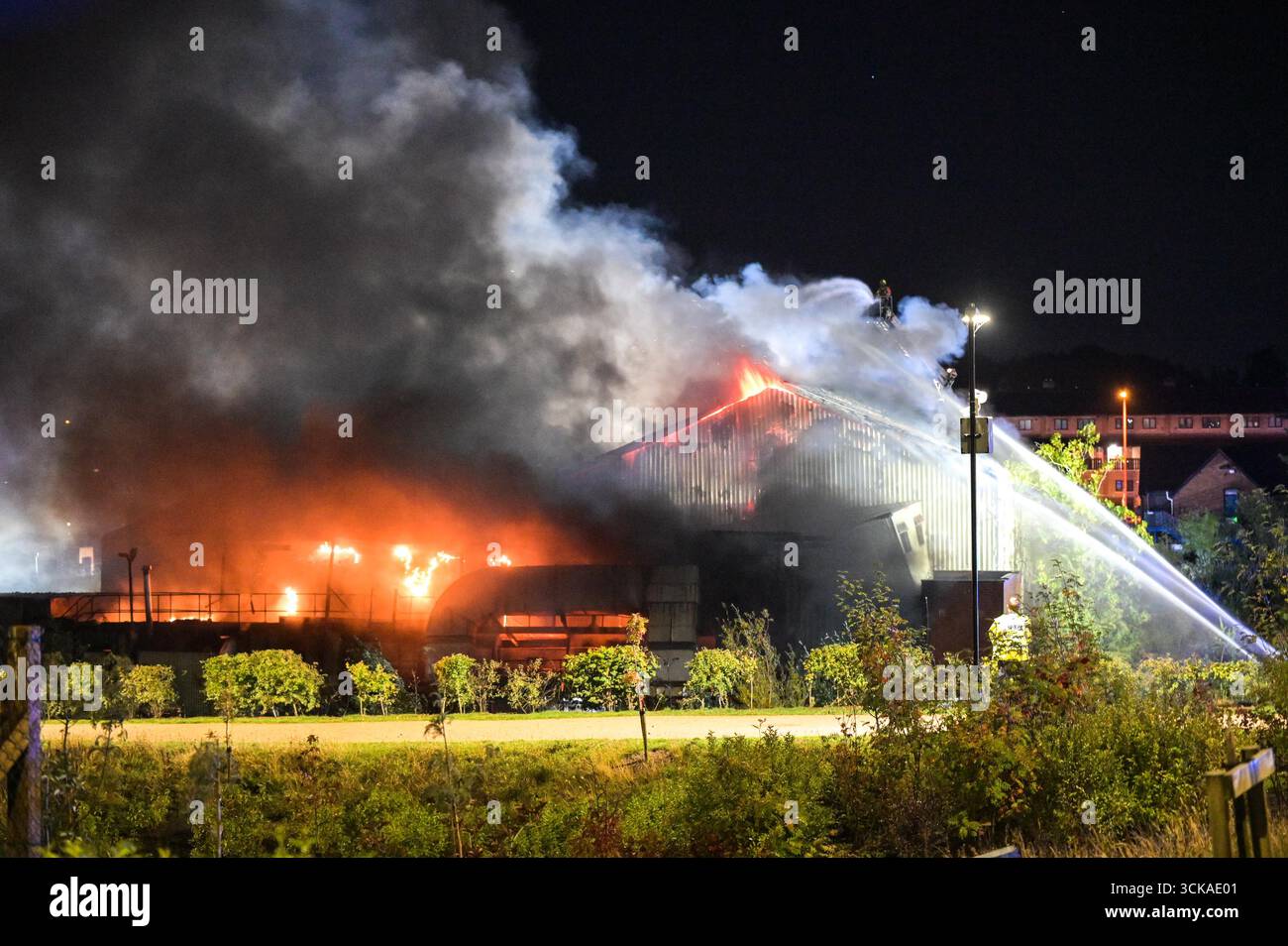 Longbridge, Birmingham, 11. September 2025. Mehr als 60 Feuerwehrleute sind in den frühen Morgenstunden des Donnerstags bei einem großen Brand in Longbridge, Birmingham, anwesend. Die Flamme hat Frankley Tyre Lagerhaus auf dem alten Gelände des MG Rover West Works erobert. Zwölf Feuerwehrfahrzeuge, zwei hydraulische Plattformen, die Vorfallskommando und verschiedene andere Ressourcen der Polizei, Cadent und des National Grid waren anwesend. Flammen leckten das Gebäude ab, als Wände einstürzten und die Feuerwehr Wasser mit Schläuchen besprühte. Die West Midlands Fire Service sagte in einem Beitrag auf Facebook: „Wir haben 12 Mannschaften, die bei einem Brand auf W anwesend sind Stockfoto