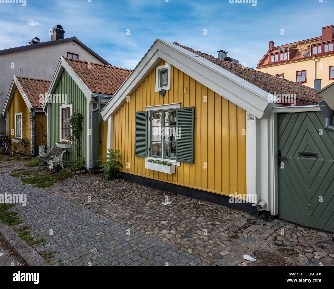 Historische einstöckige Holzhäuser mit farbenfroher gelber, grüner Abzweigung in der Altstadt von Kalmar, Schweden, die ursprünglich für einheimische Seeleute erbaut wurde Stockfoto