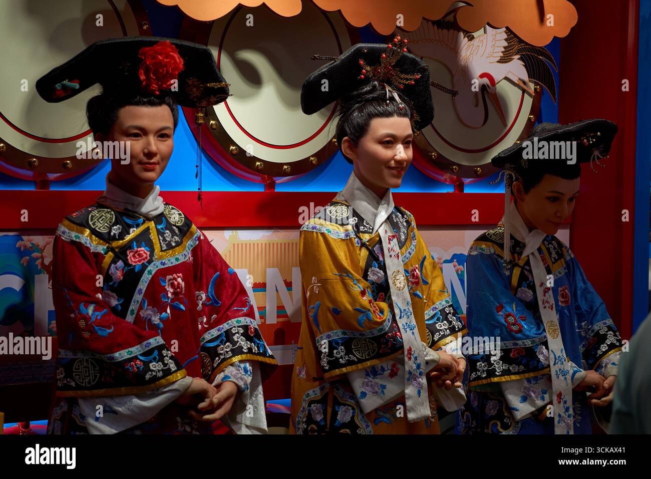 Lebensgroße und lebensechte Schaufensterpuppen oder Wachsfiguren in traditionellen chinesischen Kostümen begrüßen Kunden in einem Nanluoguxiang Hutong-Geschäft in Peking, China Stockfoto