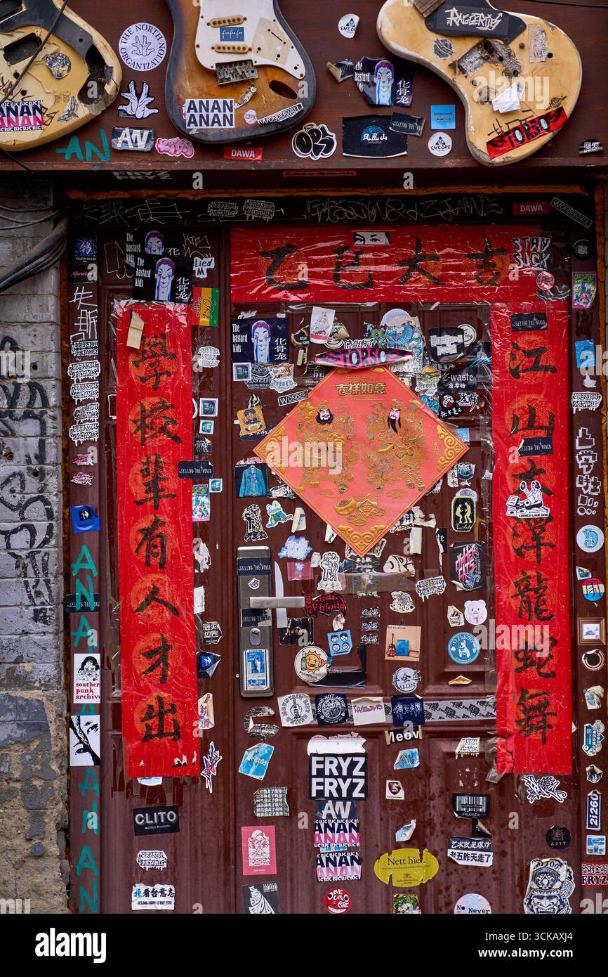 Grungy House Door voller cooler Underground-Kultur-Aufkleber im angesagten Wudaoying Hutong, Peking Stockfoto Grungy House Door voller cooler Underground-Kultur-Aufkleber im angesagten Wudaoying Hutong, Peking Stockfoto