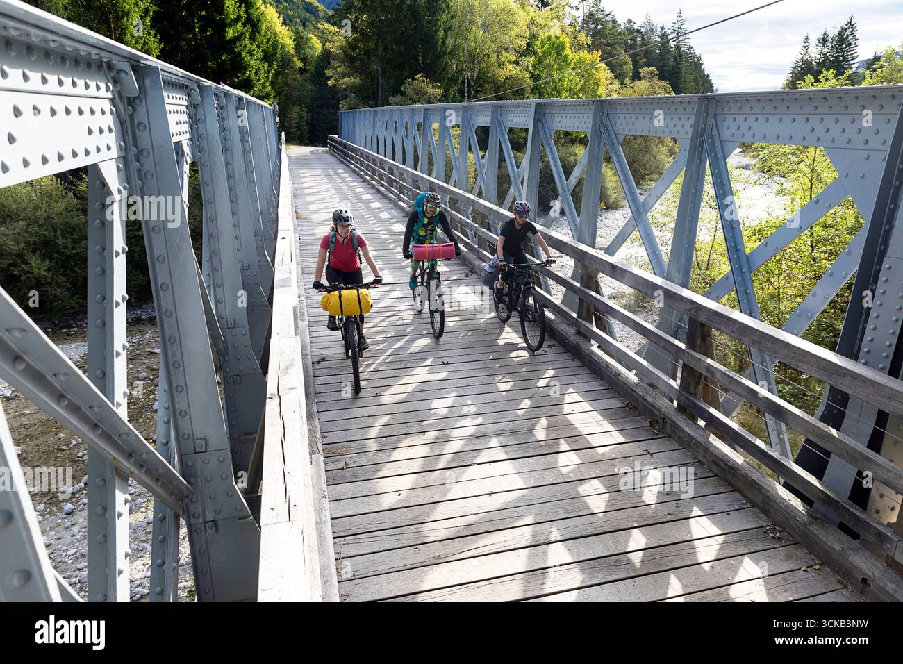 Touristen auf einer Rad- und Radtour durch Slowenien, erkunden die wunderschöne Berglandschaft in der Region gorenjska und überqueren die alte Eisenbahnbrücke Stockfoto