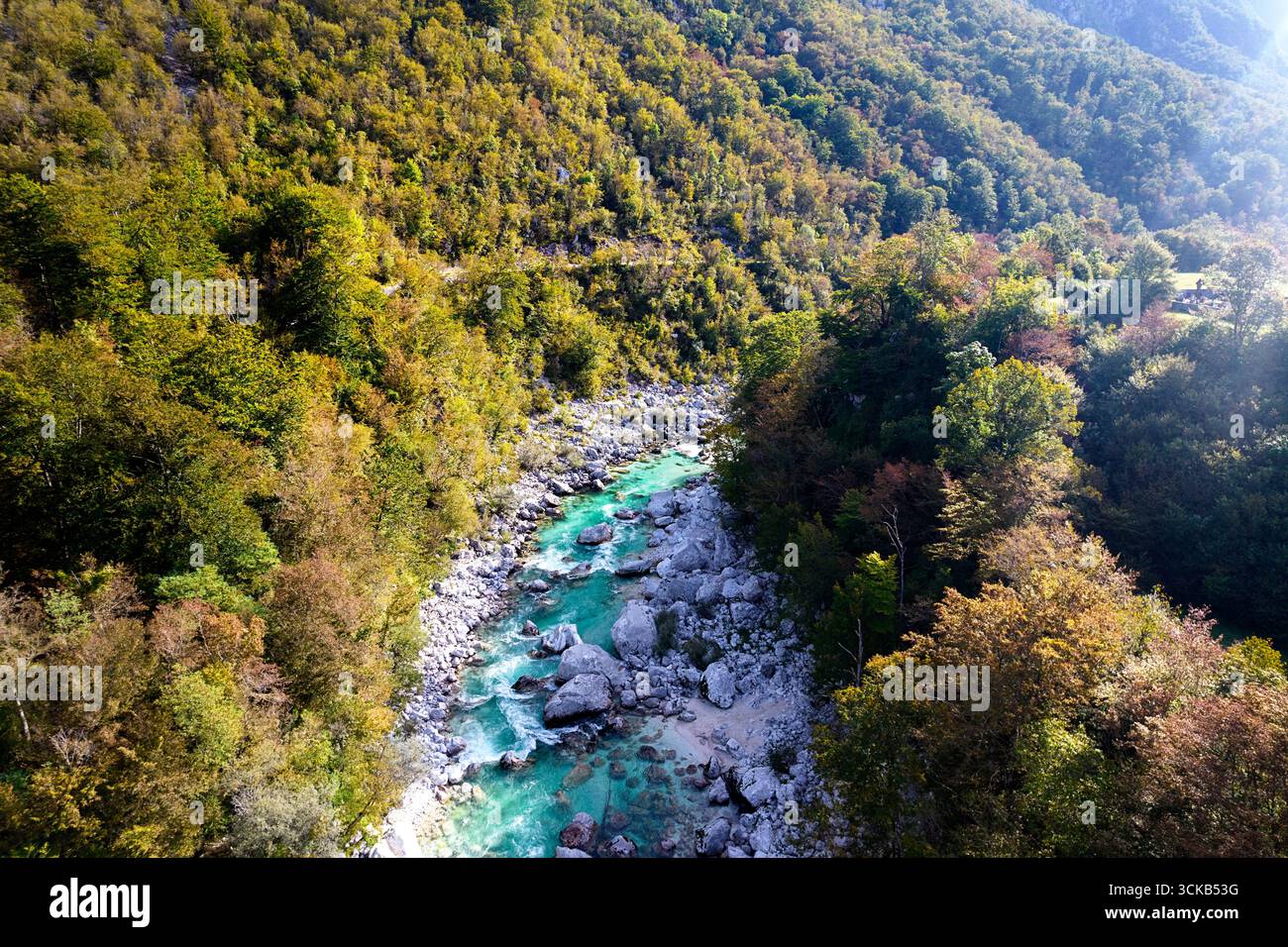 Kristallklarer türkiser Soča-Fluss, der durch die Julischen Alpen in Slowenien fließt, umgeben von dramatischen Bergen und unberührter Alpenlandschaft. Stockfoto