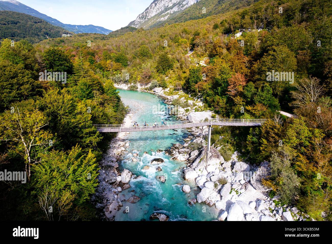 Touristen auf einer Rad- und Radtour durch Slowenien, erkunden die wunderschöne Berglandschaft und überqueren die Hängebrücke über den Fluss soca in der Nähe von kobarid Stockfoto