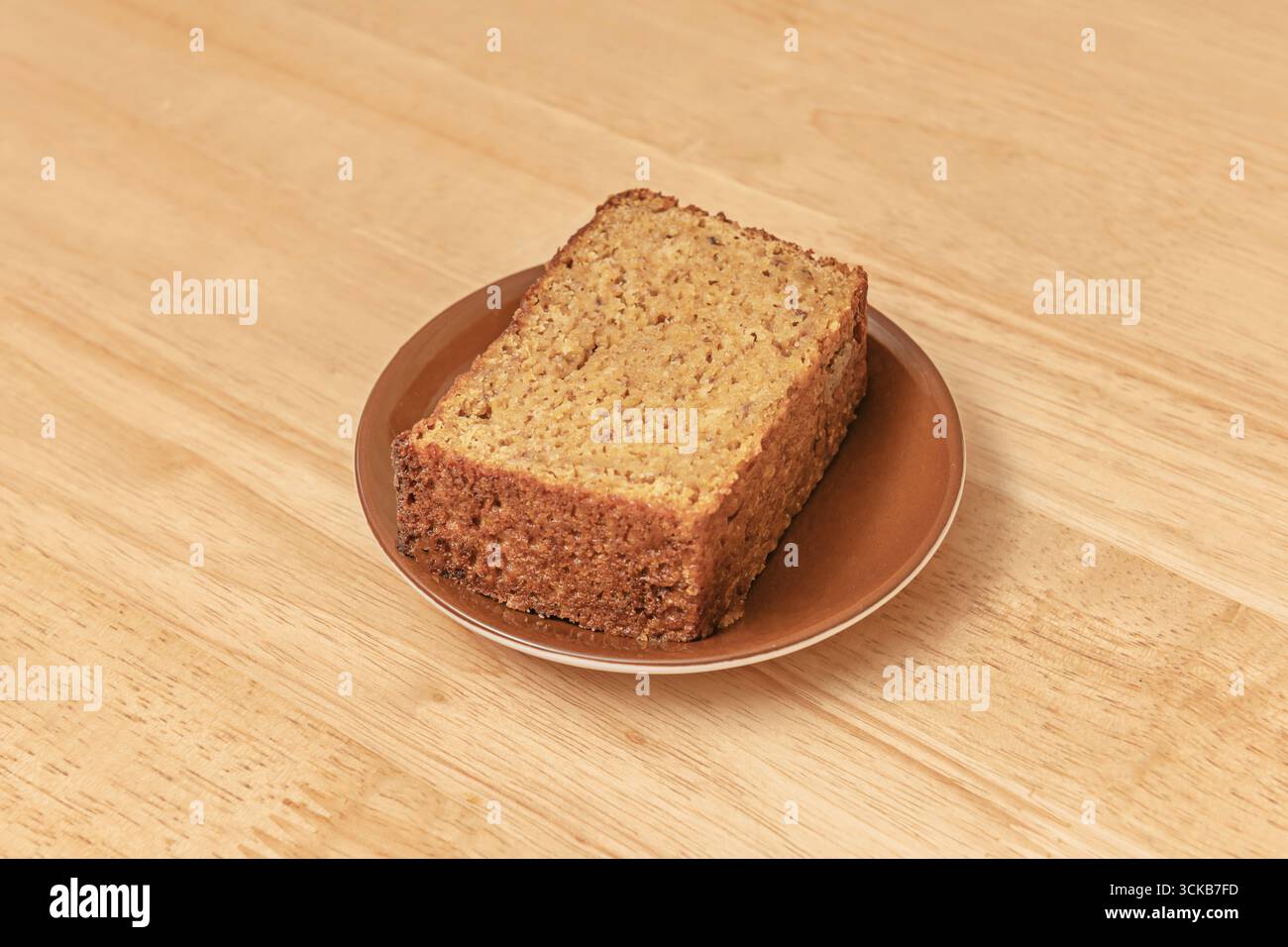 Matcha-Kuchen mit einer charakteristischen, leuchtenden grünen Farbe, gekrönt mit weißer Schokoladencreme und mit frischen Minzblättern dekoriert Stockfoto