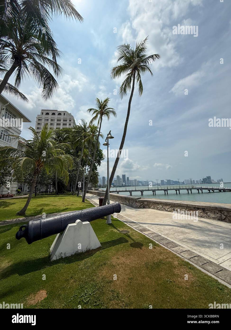 Eine Kanone in den Gärten, die auf das Meer zeigt, vor dem Eastern & Oriental (E&O) Hotel in Goerge Town, Hauptstadt Penang in Malaysia, - Smartphone-aufgenommenes Stockfoto