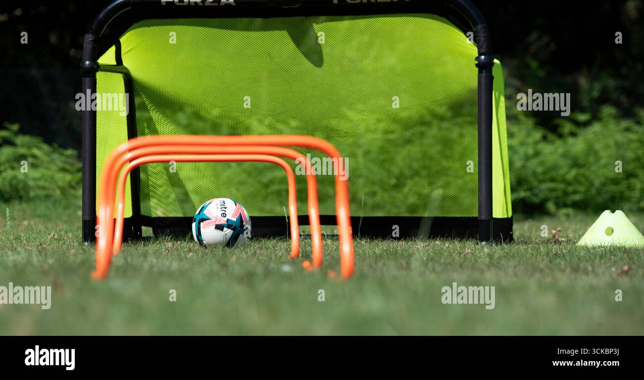 Beim Fußballtraining werden die Ausrüstung eines Fußballs, Minitore und Hürden geübt. Stockfoto