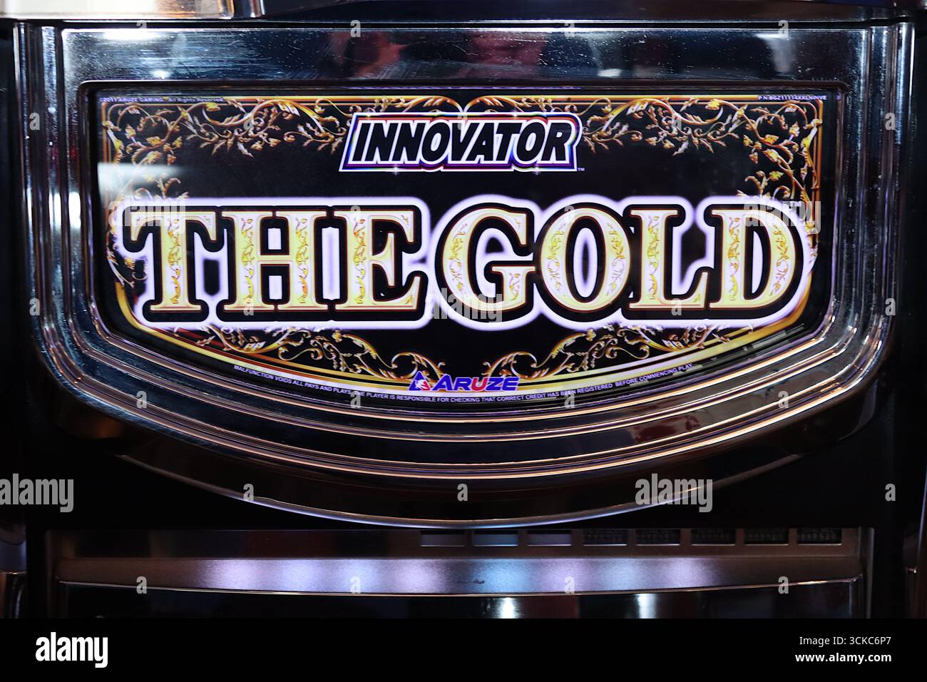 „The Gold“ Video-Slots von Innovator, einem Video-Spielautomat mit fünf Walzen und dreißig Zeilen, die die beleuchtete untere Platte und die Chromeinfassung zeigen. Stockfoto