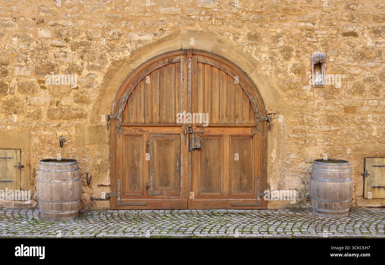 Alte braune runde Doppelholztür in einer Steinfassade Stockfoto