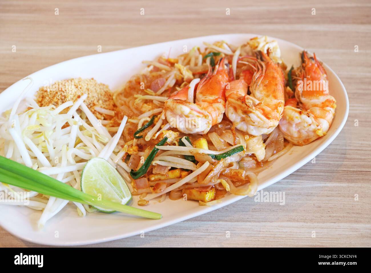 Köstliche Pad Thai Noodle mit Flussgarnelen, serviert auf Holztisch Stockfoto