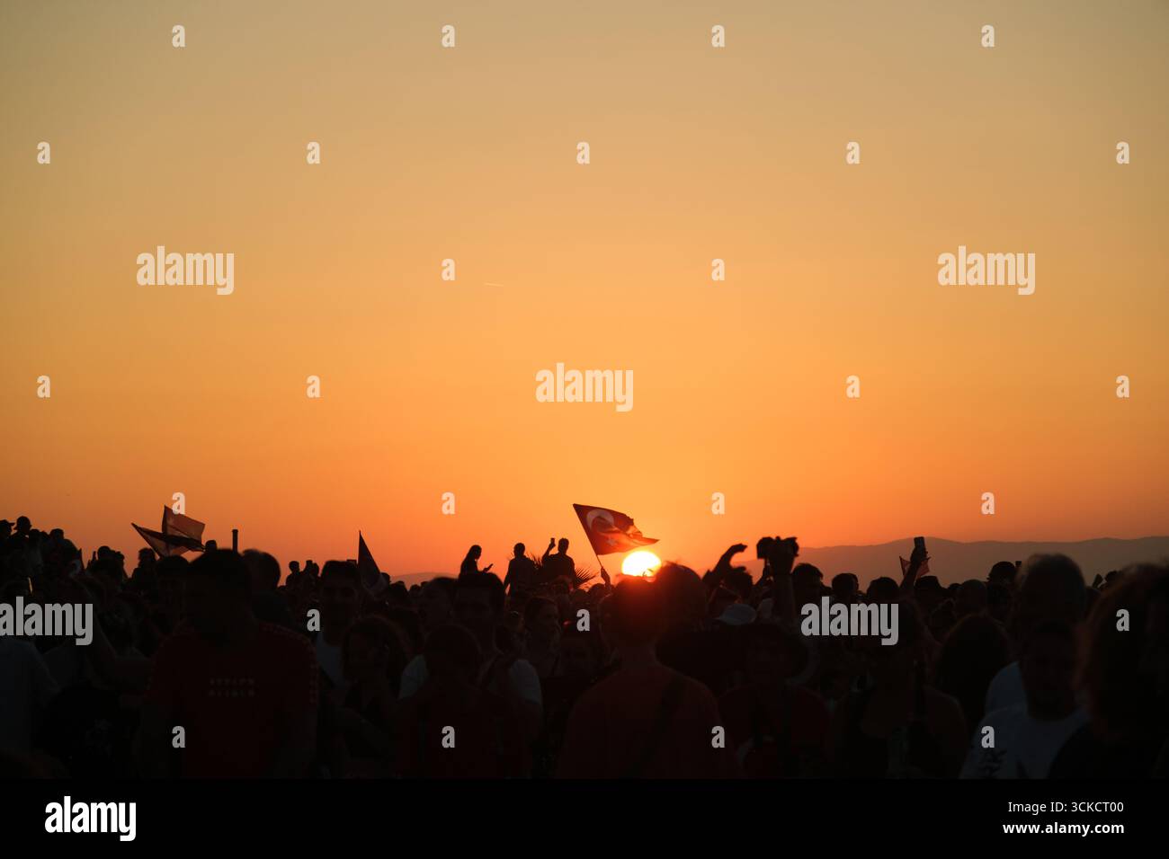 Izmir, Türkei - 9. September 2025: Foto von türkischer Flagge am Himmel mit einer Silhouette bei Sonnenuntergang, aufgenommen am Jahrestag der Befreiung Izmirs Stockfoto