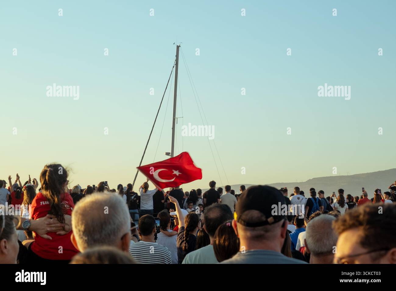Izmir, Türkei - 9. September 2025: Foto von türkischer Flagge am Himmel mit einer Silhouette bei Sonnenuntergang, aufgenommen am Jahrestag der Befreiung Izmirs Stockfoto