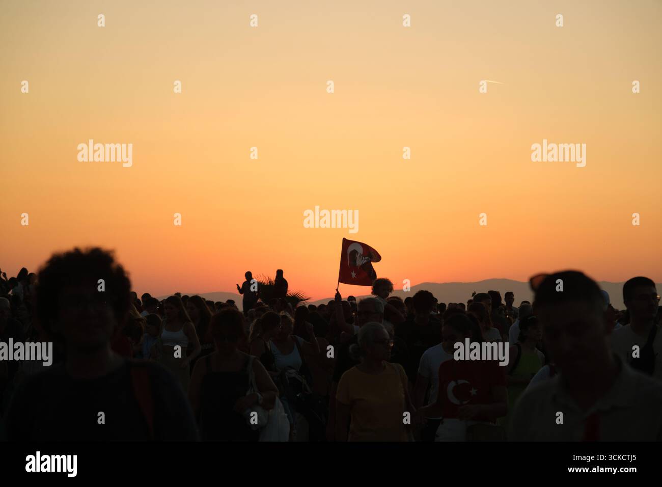 Izmir, Türkei - 9. September 2025: Foto von türkischer Flagge am Himmel mit einer Silhouette bei Sonnenuntergang, aufgenommen am Jahrestag der Befreiung Izmirs Stockfoto