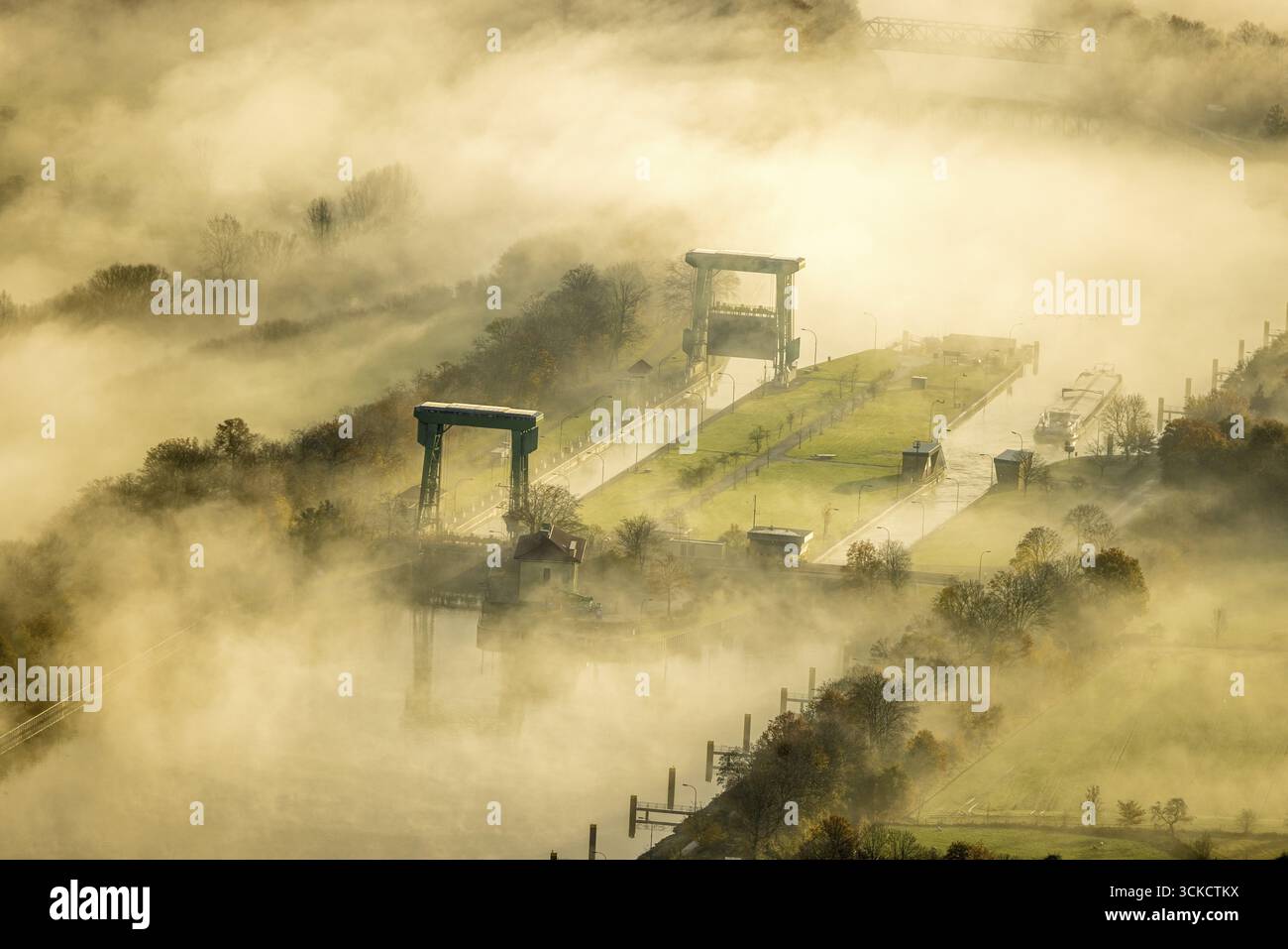 Aus der Vogelperspektive, Nebelwolken über der Flaesheimer Schleuse am Wesel-Datteln-Kanal und die Lippaue, umgeben von herbstlichen Laubbäumen, Flaesheim Stockfoto