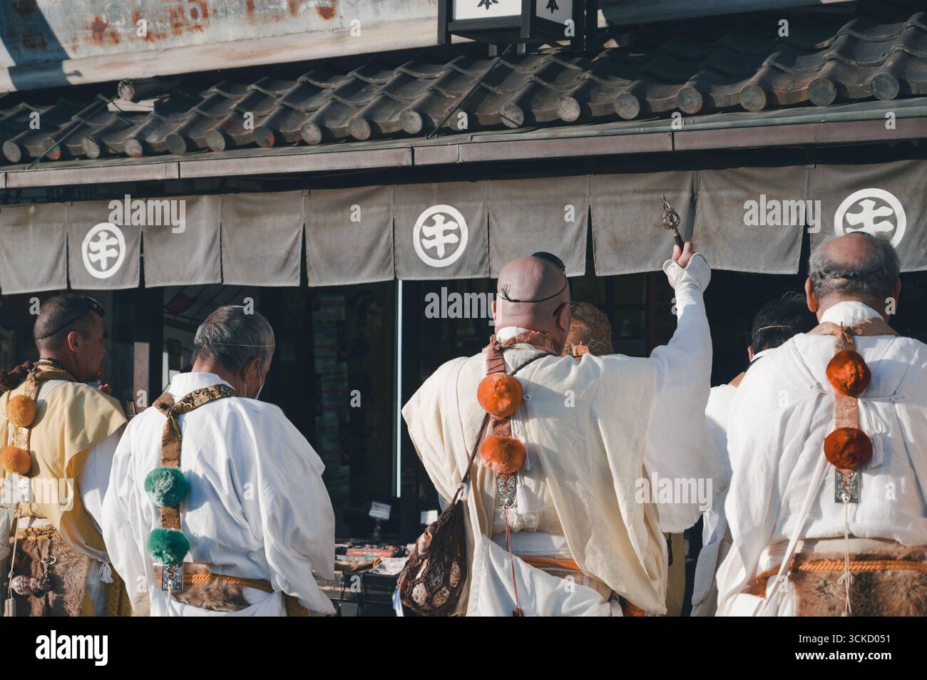 Mönche in traditionellen Gewändern führen während des Tōka Ebisu Festivals ein Segensritual vor einer Ladenfront in Kyoto durch Stockfoto
