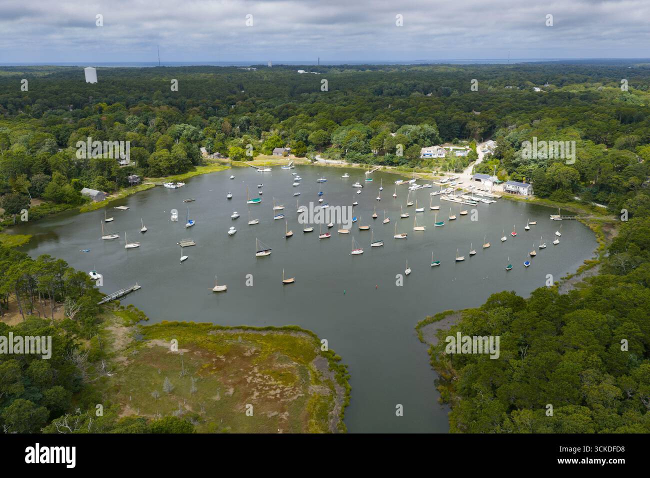 Eine Vogelperspektive zeigt eine Vielzahl von kleinen Booten, die in Arey's Pond in Orleans, MA, vor Anker gehen. Diese wunderschöne Gegend am Cape Cod erreicht Pleasant Bay. Stockfoto