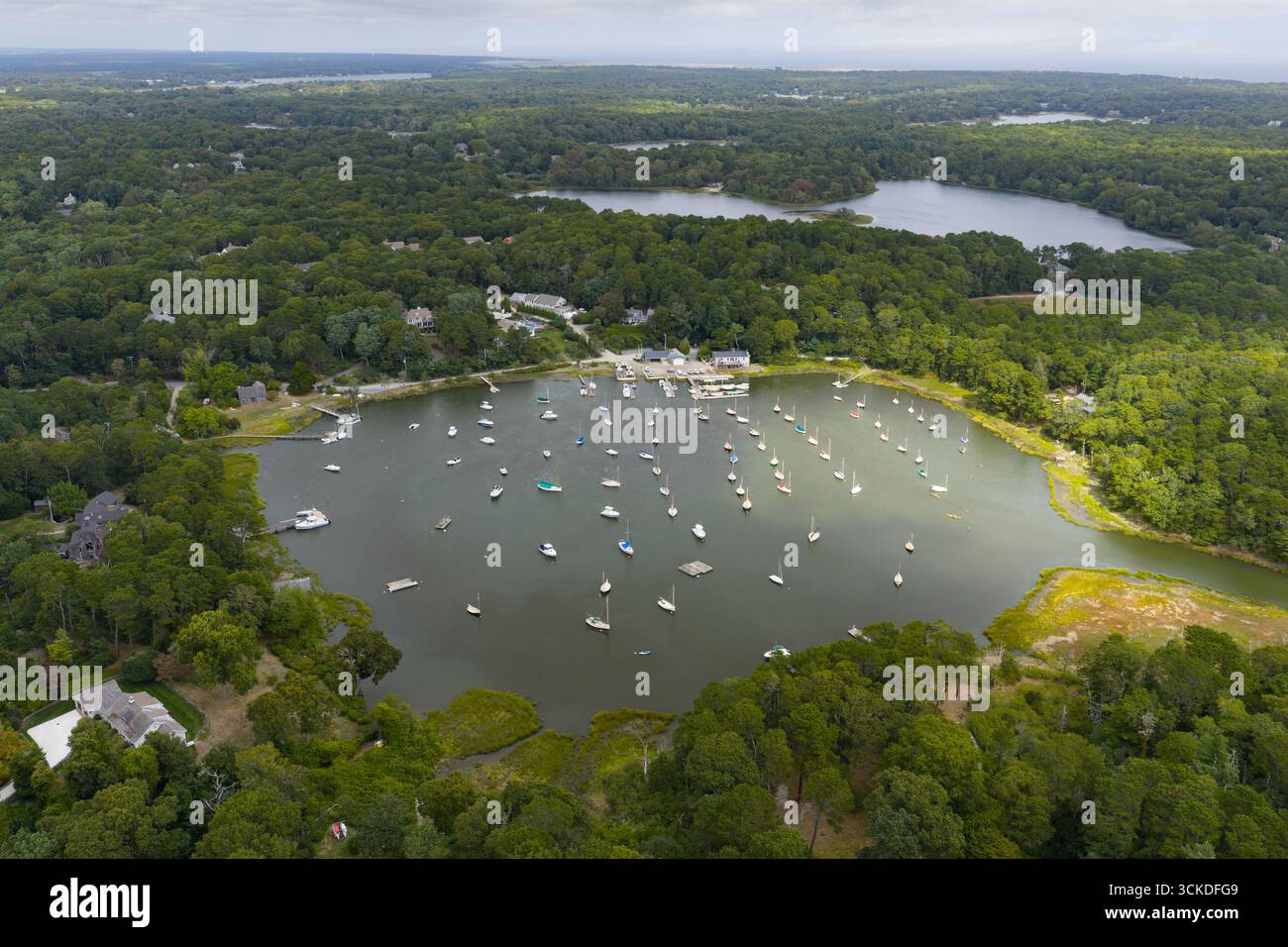 Eine Vogelperspektive zeigt eine Vielzahl von kleinen Booten, die in Arey's Pond in Orleans, MA, vor Anker gehen. Diese wunderschöne Gegend am Cape Cod erreicht Pleasant Bay. Stockfoto