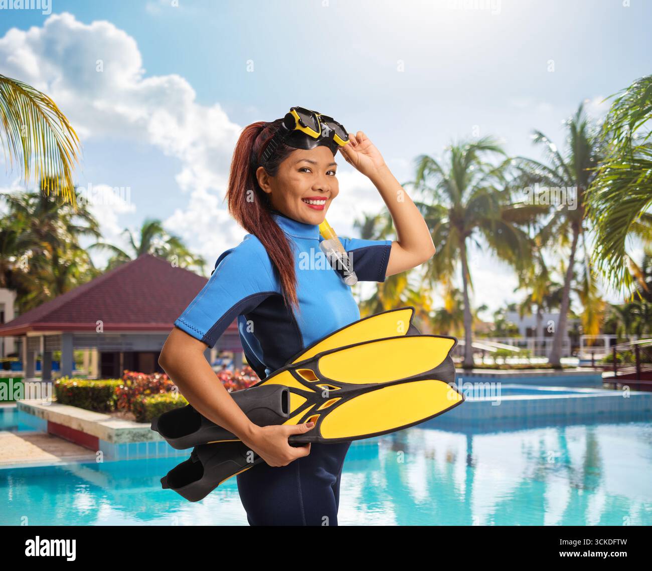 Asiatische Frau in einem Taucheranzug mit Tauchflossen und Maske am Pool Stockfoto