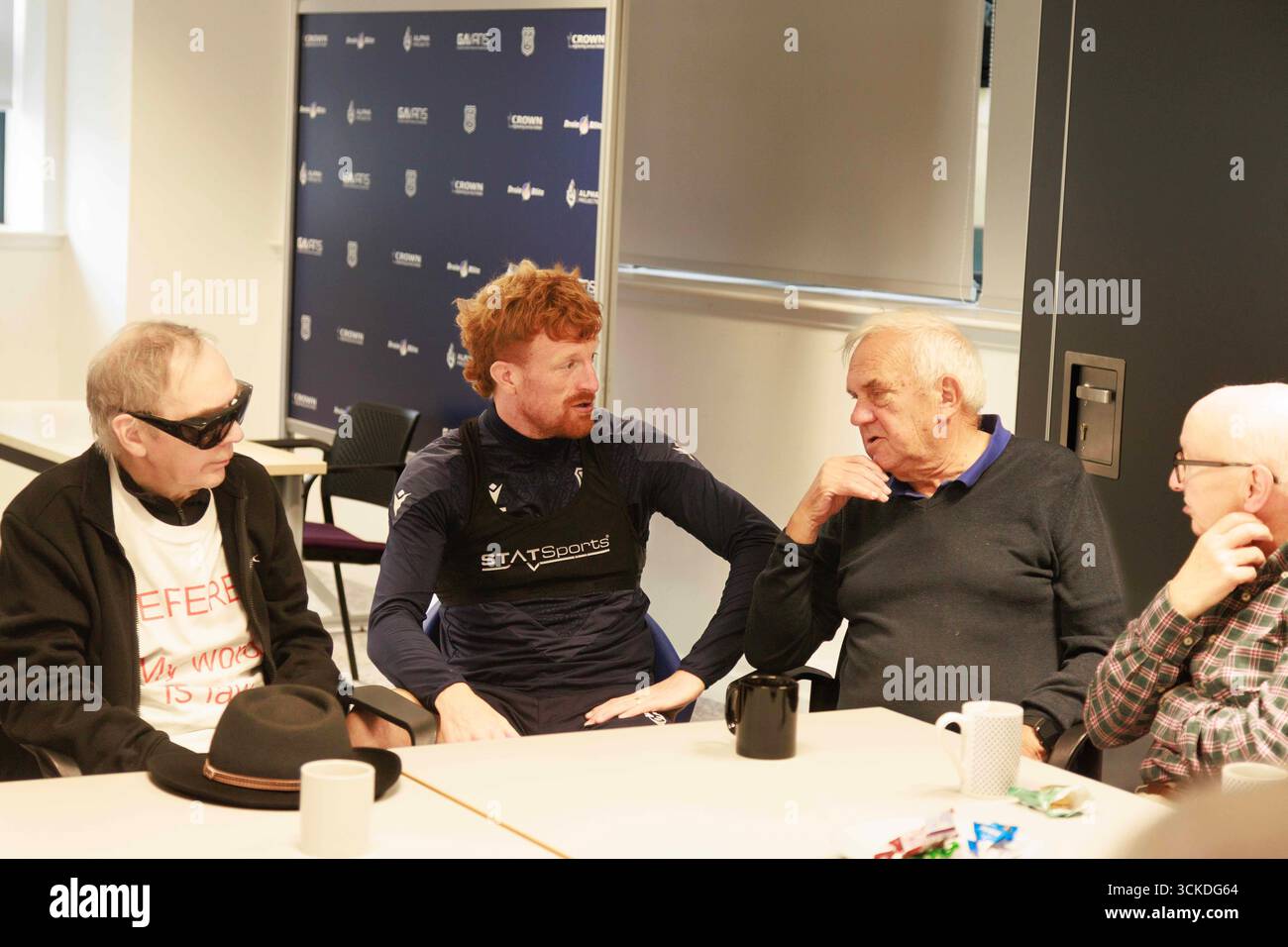 11. September 2025; Dundee and Angus College Gardyne Campus, Dundee, Schottland; Scottish Premiership Football, Dundee Training and Press Conference; Simon Murray of Dundee spricht mit Mitgliedern der Prostate Support Group während ihrer wöchentlichen Sitzung im Gardyne Training Centre Stockfoto