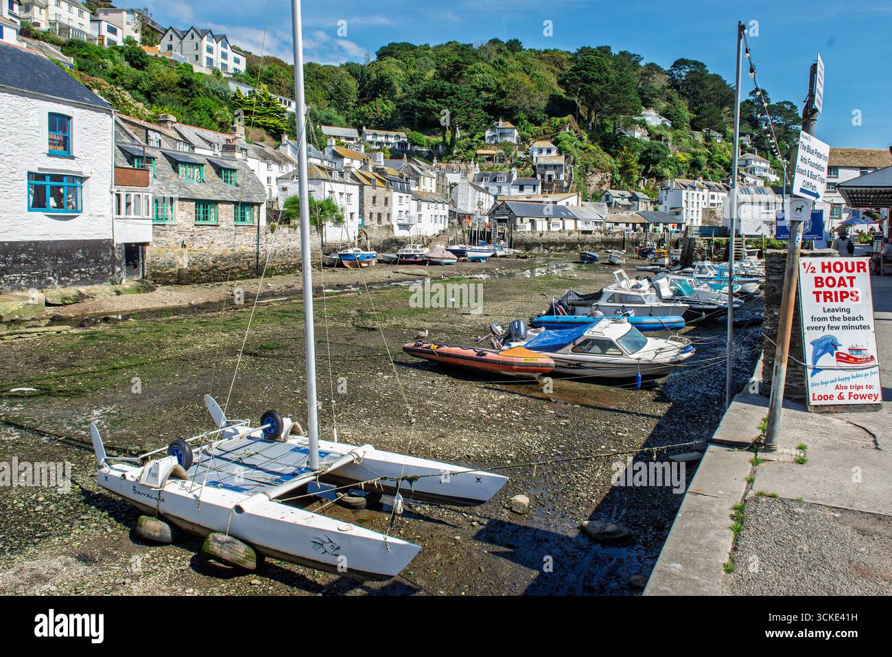 Polperro Harbour at Niedrigwasser mit Bootsschildern, Cornwall, Großbritannien Stockfoto