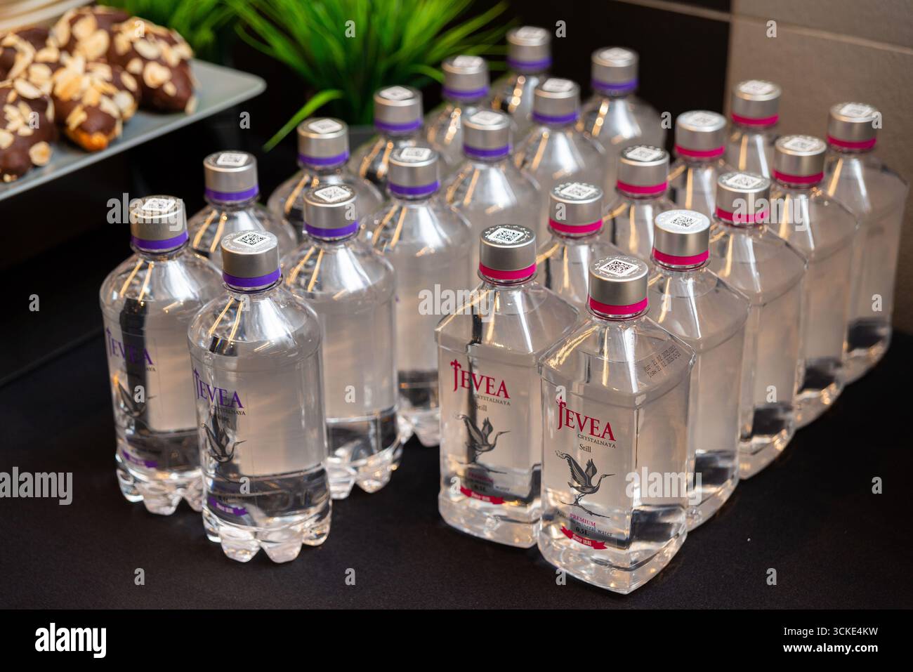 Auswahl an Mineralwasser mit Dessertpräsentation auf schwarzem Hintergrund. Stockfoto