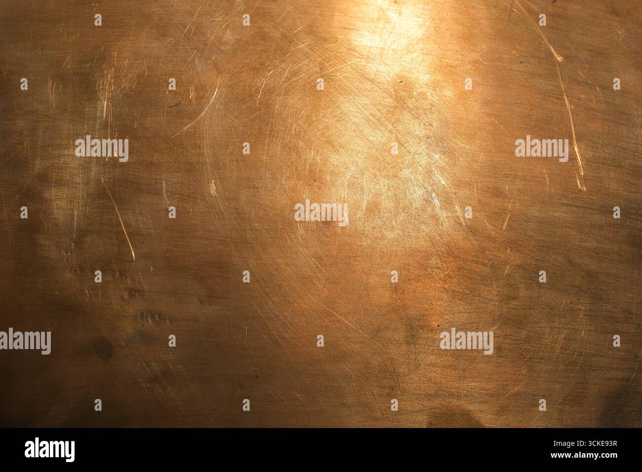 Kupferoberfläche, auf der Sonnenlicht reflektiert wird. Schmirgelstruktur. Kupferblech für Design und Textbeschriftung. Stockfoto