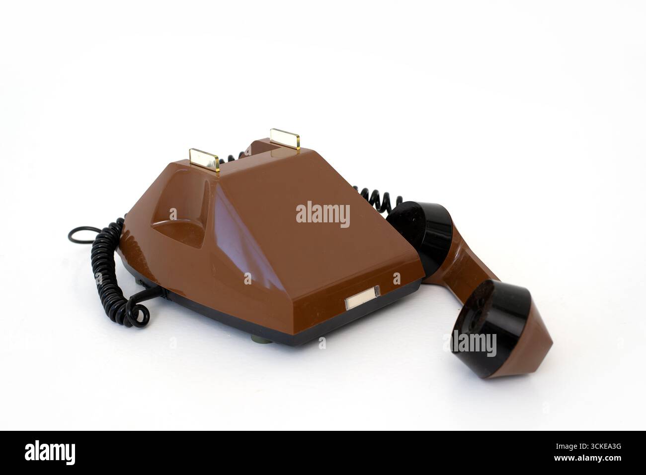 Braunes Retro-Druckknopftelefon, Hörer ruht, isoliert auf weißem Hintergrund. Stockfoto