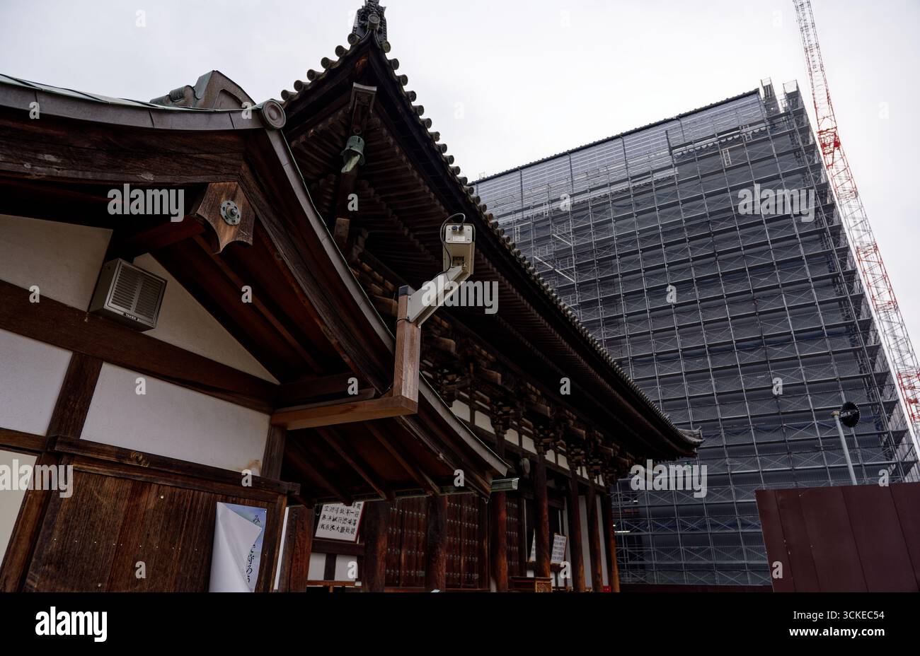 Der traditionelle hölzerne Tempel in Nara steht vor einem massiven Gebäude, das gerade restauriert wird Stockfoto